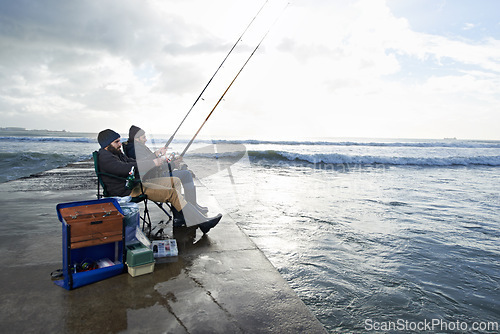 Image of Friends, fisherman and men by ocean fishing with rod, reel and equipment to catch fish for hobby. Nature, sports and people cast a line for fun, relaxing or adventure on holiday, vacation and weekend