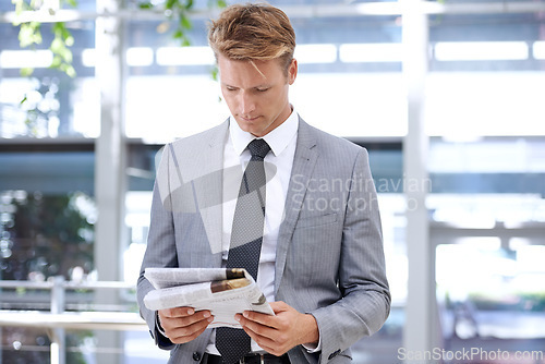Image of Businessman, reading and newspaper in office for headlines, morning print and corporate information in accounting. Accountant, news and current affairs on global finance and analysis in workplace