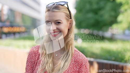 Image of Smiling Young Woman in a Sunny Urban Park