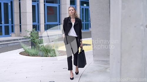 Image of Confident Businesswoman Walking in Urban Setting