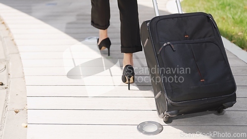 Image of Business Woman Walking With Rolling Suitcase Outdoors