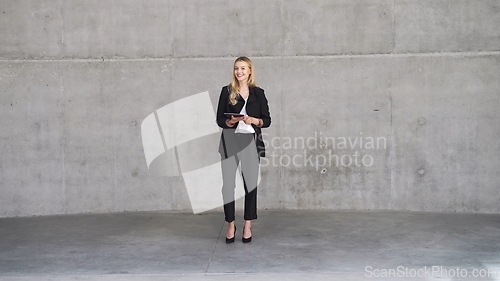 Image of Confident Businesswoman Standing with Tablet in Modern Office