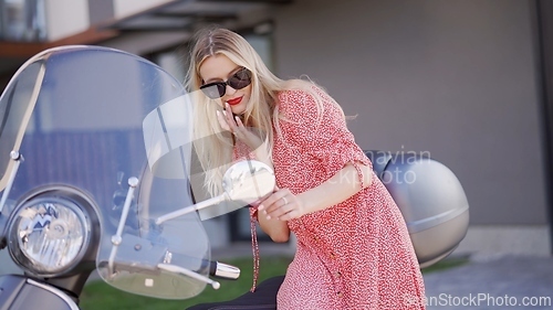 Image of Fashionable Woman Leaning on a Vintage Scooter Outdoors