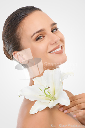 Image of Makeup, beauty and woman with flower in studio with natural, glow and cosmetic face routine. Portrait, confident and young female person with floral plant for facial cosmetology by white background.