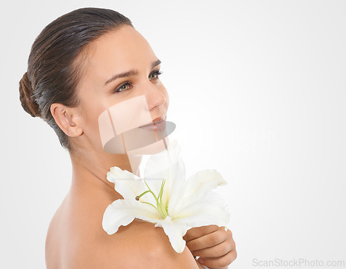 Image of Makeup, flower and beautiful woman in studio with glamour, glow and cosmetic face routine. Beauty, mockup and young female person with floral plant for facial cosmetology by white background.