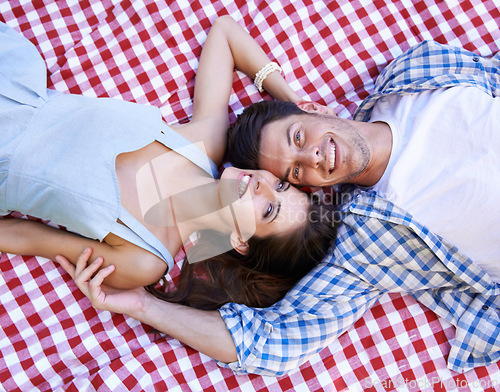 Image of Happy, couple and blanket in portrait for picnic with love, connection and bonding on date from above. Man, woman and face with relax on ground for vacation, unity or holiday in relationship together