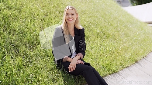 Image of Smiling Woman in Black Suit Sitting on Green Grass