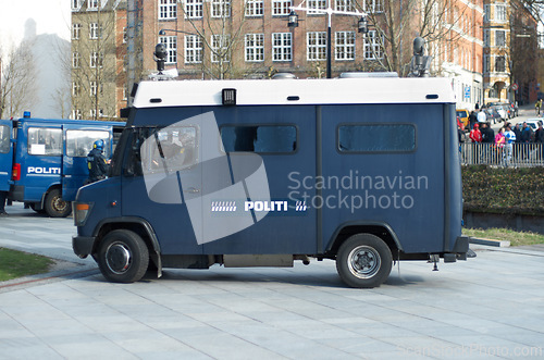 Image of Police, van and city for transport, safety or protection service for public justice in in street. Vehicle, law enforcement and outdoor for danger, arrest and armored truck on urban road in Copenhagen