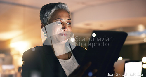 Image of Business woman, manager and tablet at night in office to search online report, scroll information and website planning. Happy mature entrepreneur working late on digital data with social network app