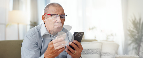 Image of Phone, medicine and senior man with home research, reading label and learning of telehealth services. Online patient with pills bottle, tablet and mobile for information or health benefits on a sofa