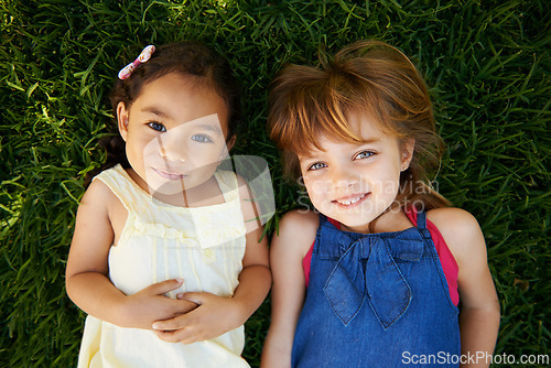 Image of Happy, nature and girl children on grass play together in outdoor park or garden from above. Smile, bonding and high angle portrait of young kid friends relaxing in field lawn on holiday or weekend.