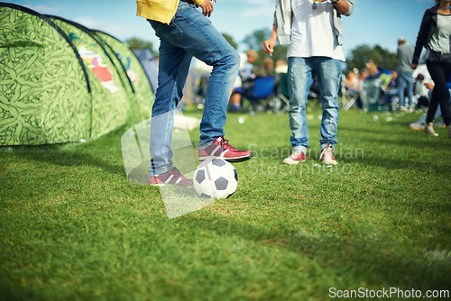 Image of Man, feet and playing with soccer ball outside of his tent group of colourful camping. Row of marquees placed on ground at musical concert, entertainment event and carnival celebration sporty party