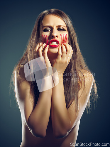 Image of Portrait, rage and woman with anger, blood and person on a dark studio background. Face, model and girl with expression or upset with emotion and furious with stress and emoji with conflict or crisis