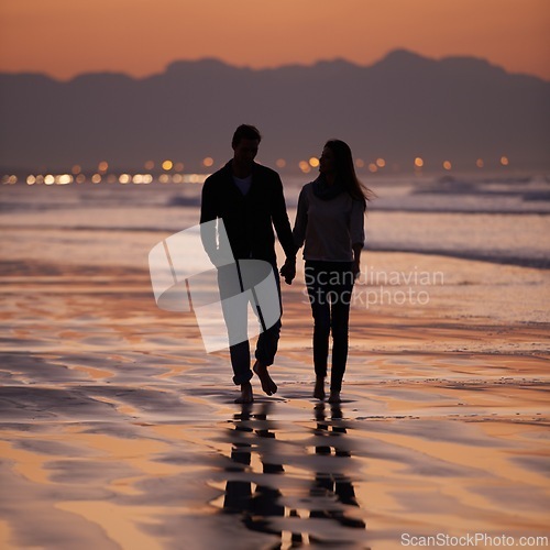 Image of Silhouette, sunset and couple holding hands outdoor with back view and nature, travel and bonding for love and commitment. People walk on beach, trust and loyalty with adventure together and shadow