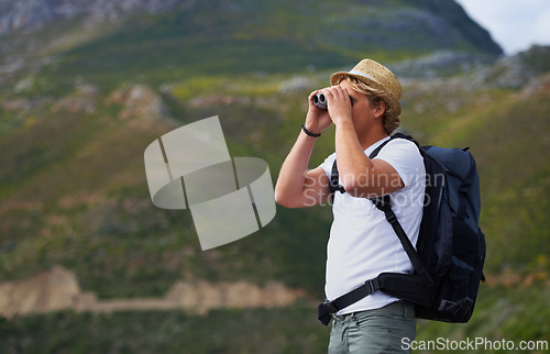 Image of Man, hiker and binoculars with backpack for sightseeing, outdoor travel or hiking on mountain in nature.Young person, traveler or tourist with bag or optical instrument for view, vision or scope