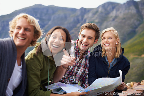 Image of Happy people, friends and pointing with map for travel, location or destination on mountain in nature. Young group with smile, document or geographic paper for navigation, help or outdoor tourism