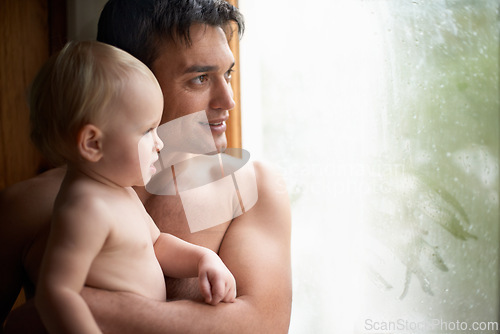 Image of Window, rain and father with baby in house for bonding, playing or having fun in their home together. Water, glass or dad with curious kid watching storm, weather or raindrops for learning or games
