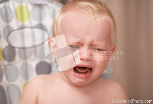 Image of Baby, sad child and crying in home alone in nursery with colic, frustrated and unhappy. Young kid, toddler and tears of infant screaming for stress, depression and upset with face expression of pain