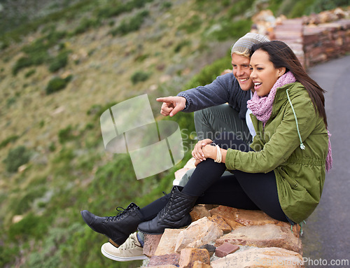 Image of Happy couple, pointing and travel for sightseeing, journey or outdoor view together in nature. Young man and woman with smile enjoying holiday, vacation or getaway in natural environment on mountain