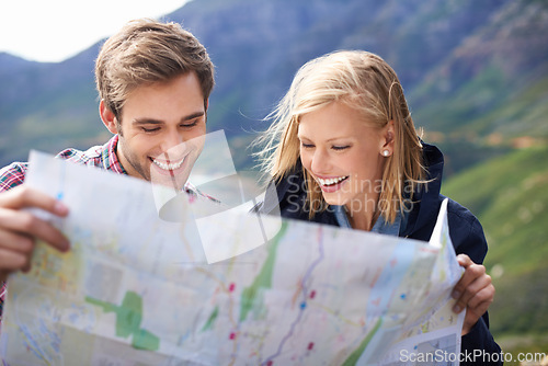 Image of Happy people, friends and map with location for travel or destination on mountain in nature. Young couple with smile, document or geographic paper with routes for navigation, help or outdoor tourism