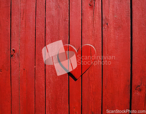 Image of Red painted wooden wall with heart as a symbol of love and frien