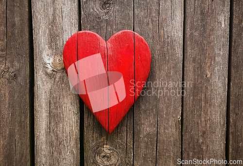 Image of Bright red heart as a symbol of love and friendship on wooden wa