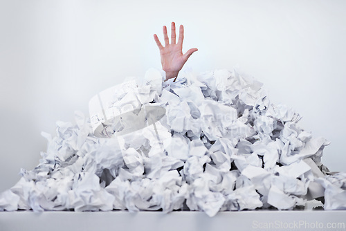 Image of Person, hand and paper pile or trapped in deadlines for work responsibilities for overwhelmed, exhausted or problem. Fingers, buried and employee reaching for help or business, burnout or documents