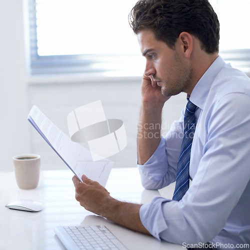 Image of Businessman, paper and thinking in office for report, analysis and brainstorming with strategy at desk. Professional man, documents and reading with planning for budget, schedule or agenda at work