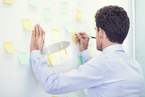 Image of Businessman, writing and sticky notes in office for planning, brainstorming and project strategy with rear view. Entrepreneur, employee and ideas for agenda, schedule and proposal information at work