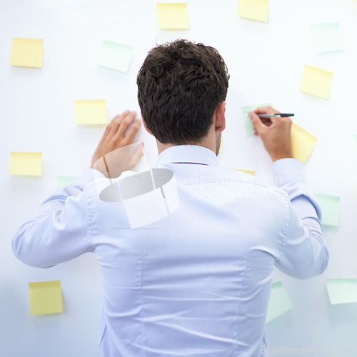 Image of Businessman, writing and sticky notes in office for planning, brainstorming and project with rear view. Entrepreneur, employee and ideas for agenda, schedule and proposal information at work
