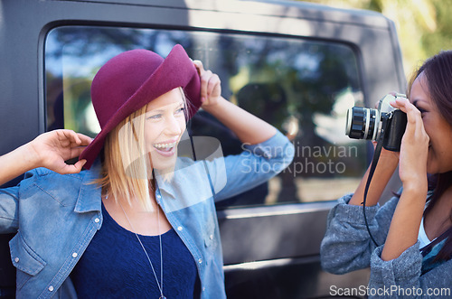 Image of Camera, photography and friends on road trip with journey, travel and creative hobby or photoshoot of model posing. Young people, women or photographer shooting by car for outdoor fashion and hat