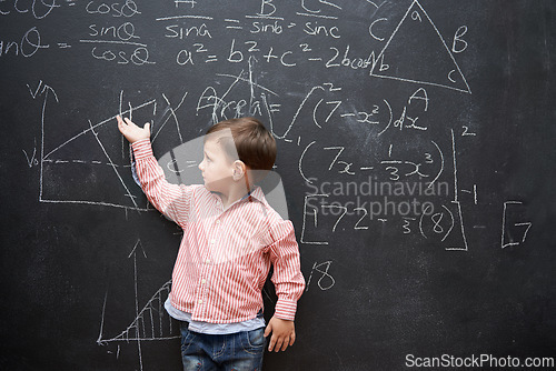 Image of Child, boy and blackboard with math or equations for knowledge, numbers and hand gesture in classroom at school. Kid, student and learning by chalkboard for problem solving, studying and preschool