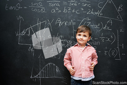 Image of Kid, boy and face with smile by blackboard with equations, numbers and problem solving in classroom at school. Child, student and happy for knowledge, learning and chalkboard with math and preschool