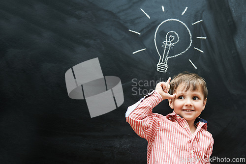 Image of Child, thinking and lightbulb on chalkboard for solution, learning and creative mindset in school on mockup space. Happy kid, student or boy with light bulb, emoji and blackboard of knowledge or idea