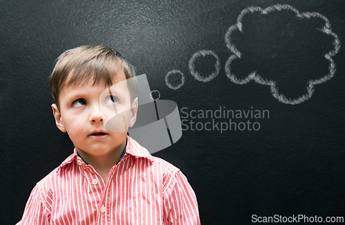 Image of Child, boy and thinking with thought bubble on blackboard for creative idea, drawing and illustration in classroom. Student, kid and face with daydreaming, contemplating and question with chalkboard