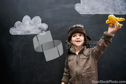 Image of Child, boy and happy by blackboard with plane for creative fun, playing and drawing of clouds for education. Student, kid and confidence with airplane, chalkboard or illustration for knowledge or sky