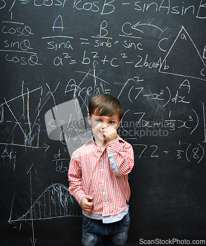 Image of Child, boy and portrait with smile by blackboard with equations, numbers and education in classroom at school. Kid, student and happy for knowledge, learning and chalkboard with math and preschool