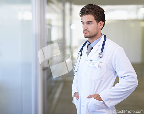 Image of Doctor, man and thinking in hospital with healthcare for wellness, medicine and surgery with stethoscope by window. Medical, professional and expert with ideas for diagnosis, health and decision