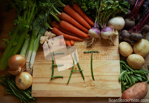 Image of Vegetables, chopping board and kitchen with variety ingredients with the message eat. High angle, fresh from the earth and healthy green foods, herbs or organic produce harvest on wooden piece