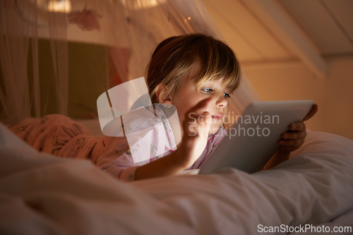 Image of Child, bedroom and tablet at night, relaxing and watching with technology for streaming or browsing. Little girl, tech and internet for online games or digital reading with touch and playing in bed