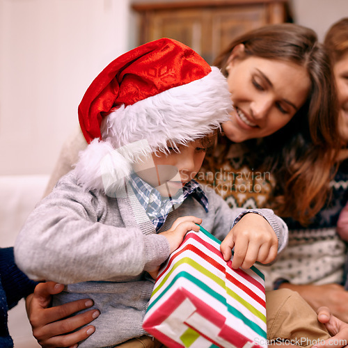 Image of Christmas, happy family and kid with gift box in living room with smile, gratitude and bonding together in home. Mother, father and son with present, love and festive holiday celebration on sofa.