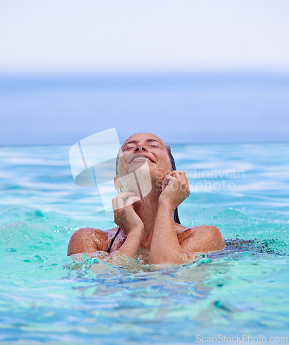 Image of Face, smile and summer with woman in swimming pool for travel, holiday or vacation on blue sky. Tropical, wellness and wet with happy young swimmer person in water to relax at resort for getaway