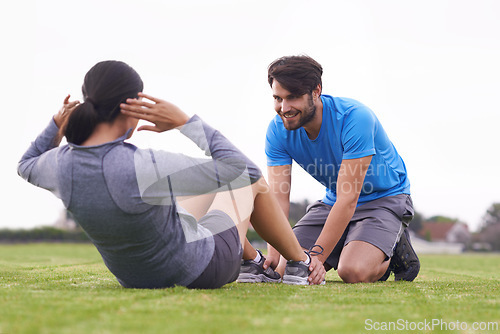 Image of Personal trainer, man and woman with sit ups on grass for fitness, training and helping hand in summer. People, support and motivation for abdomen exercise with workout on park lawn in Australia