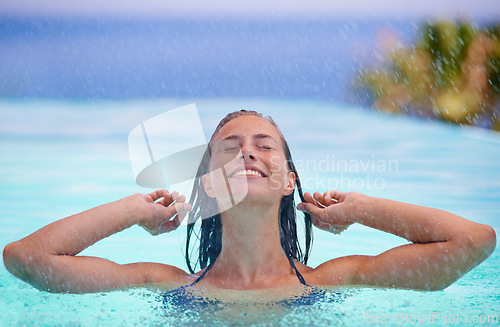 Image of Face, smile and rain with woman in swimming pool for travel, holiday or vacation as tourist. Relax, water and wellness with happy young swimmer person outdoor at tropical resort for getaway trip