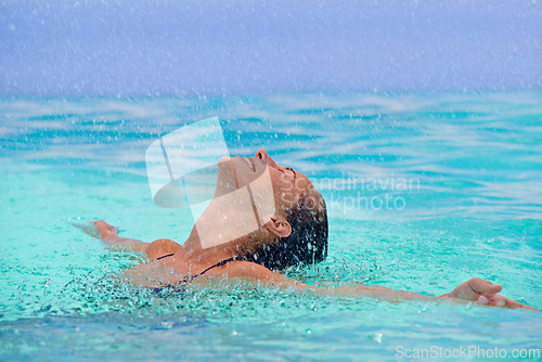 Image of Rain, smile and swimming with woman in pool for travel, holiday or vacation as tourist. Relax, smile and water with happy young swimmer person outdoor at tropical resort for wellness or hospitality