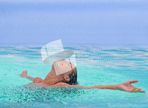 Image of Face, freedom and rain with woman in swimming pool for travel, holiday or vacation as tourist. Relax, smile and wet in water with happy young swimmer person outdoor at tropical resort for getaway