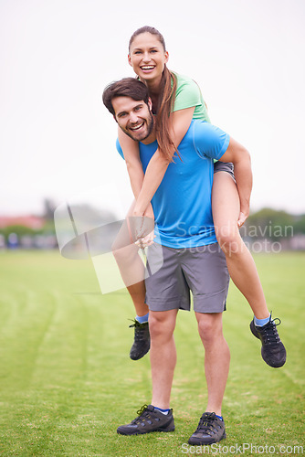 Image of Couple, piggy back and exercise in park with portrait, smile and bonding with health in nature on grass. People, man and woman with care, support and laughing on lawn for training together in England