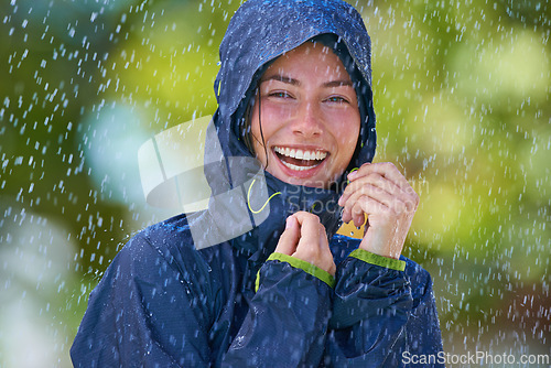 Image of Woman, rain and portrait with laughing from winter climate, water and weather outdoor in a park. Happy, travel and female person with jacket for cold on holiday and vacation with raincoat and joy