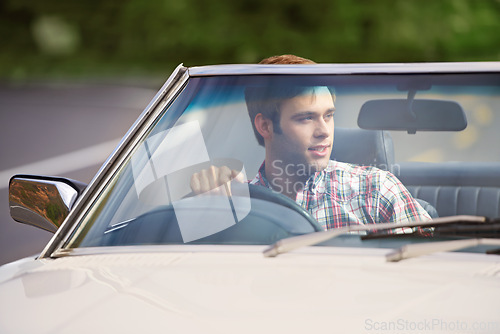 Image of Happy man, road trip and driving car for travel, adventure or outdoor journey in nature. Young male person with smile in convertible vehicle for transportation, holiday getaway or drive on street
