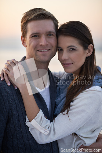 Image of Love, hug and couple on beach with sunset sky for tropical holiday adventure, relax and bonding together. Commitment, happy man and woman on romantic date with ocean, evening and embrace on vacation.